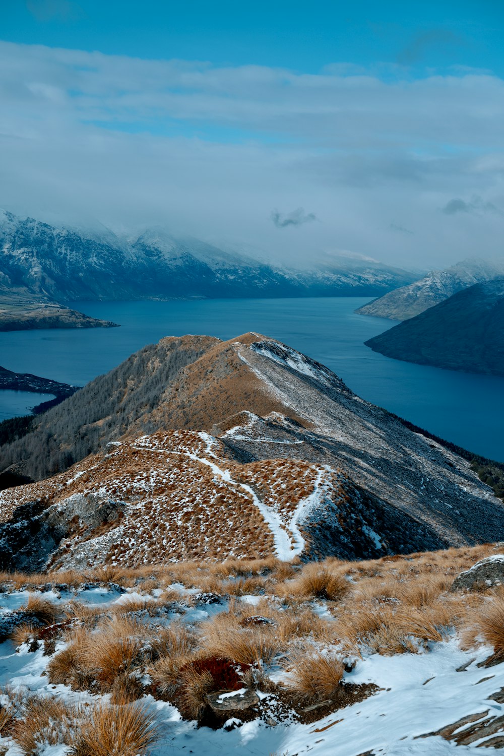 a snow covered mountain with a body of water in the distance