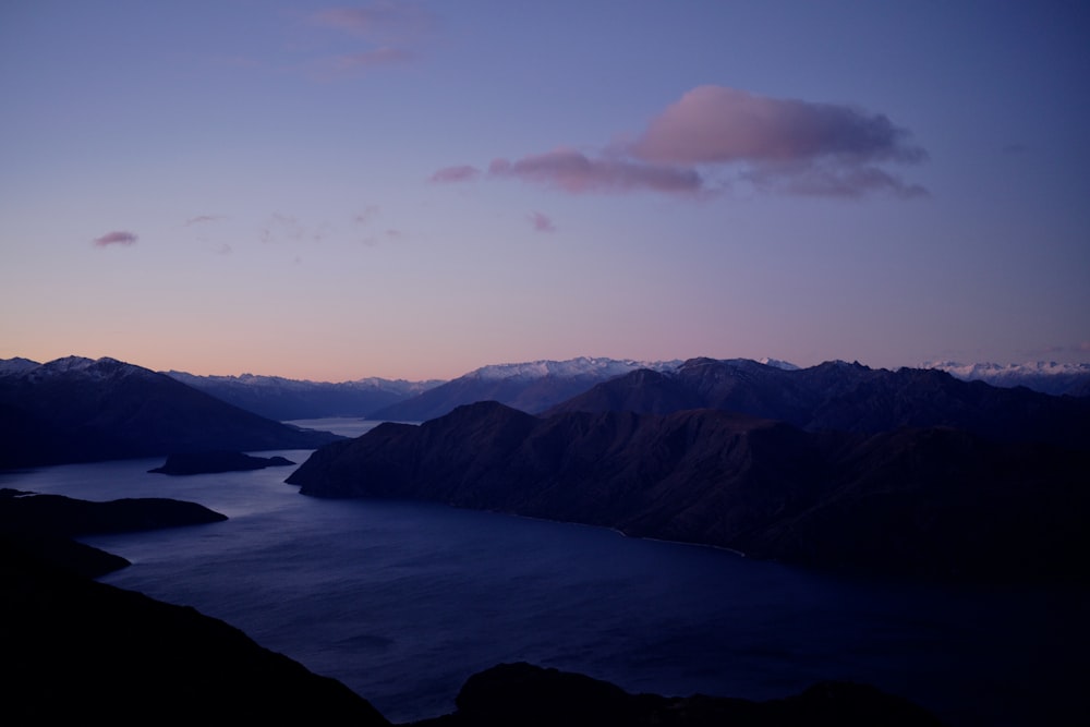 a view of a lake and mountains at dusk