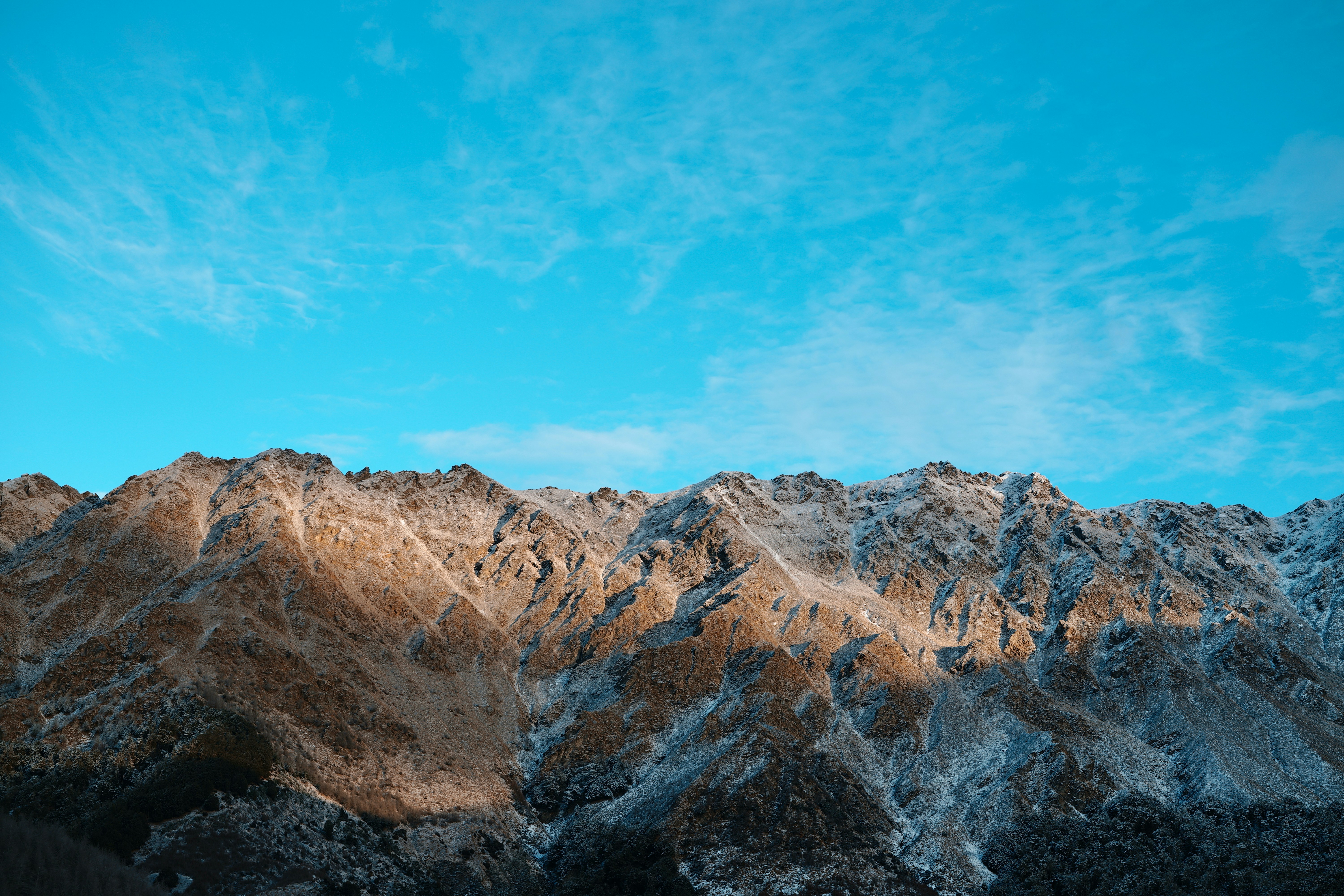 Una cadena montañosa con un cielo azul al fondo
