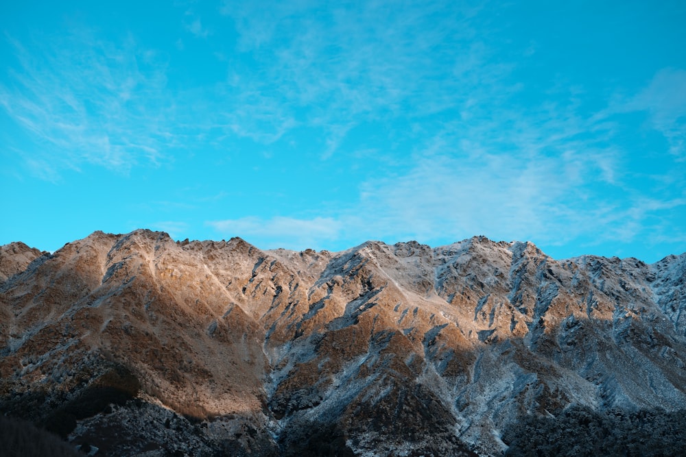 a mountain range with a blue sky in the background