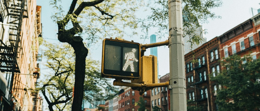 a yellow traffic light sitting on the side of a road