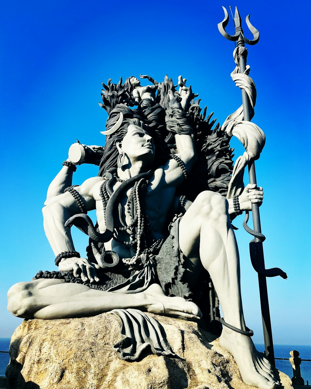 a statue of a woman sitting on top of a rock