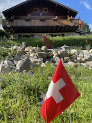 a red and white flag in front of a building