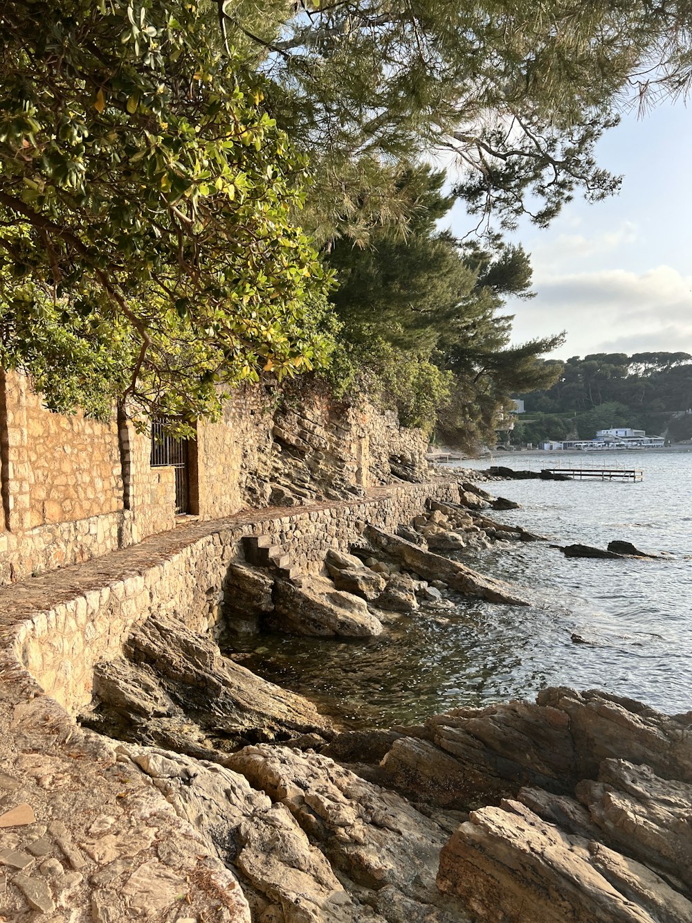 a stone wall next to a body of water