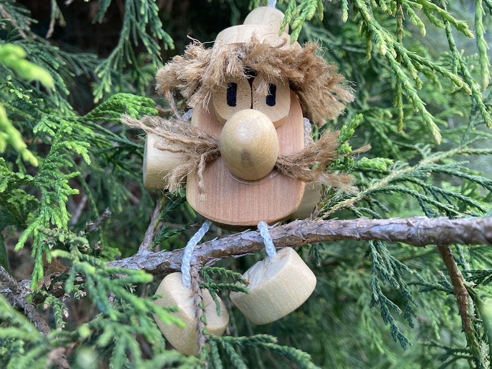 a wooden toy hanging from a tree branch