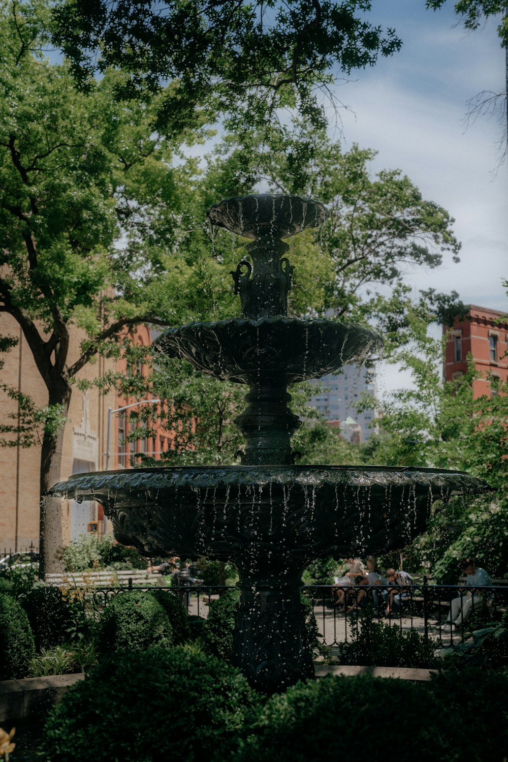 a water fountain surrounded by trees and bushes