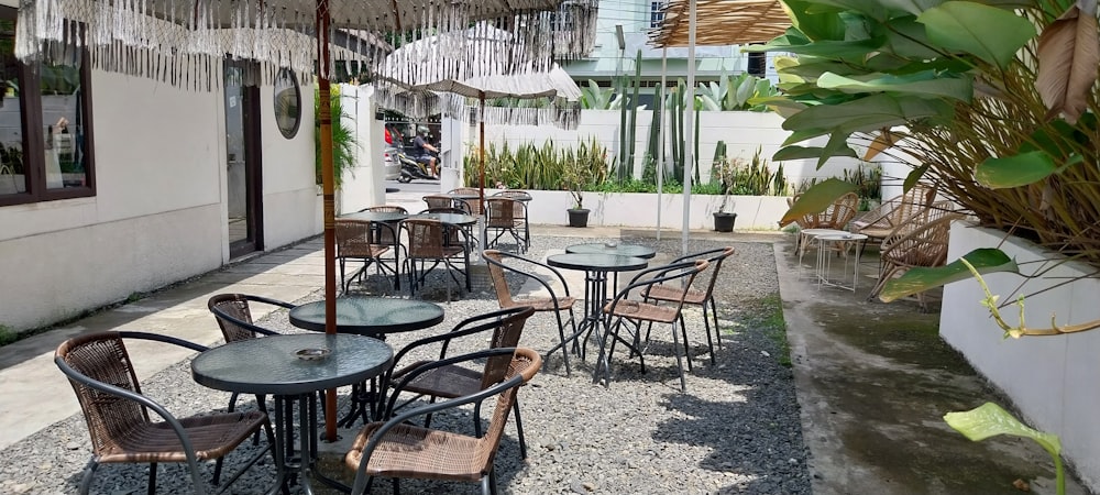 a patio with tables and chairs and an umbrella