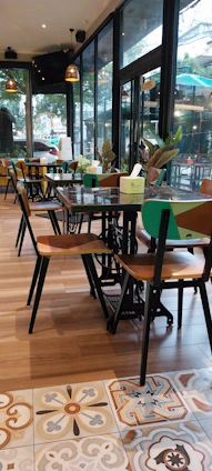 Cozy interior of eco-café urbano with warm wooden tones and green plants reflecting the brand colors.