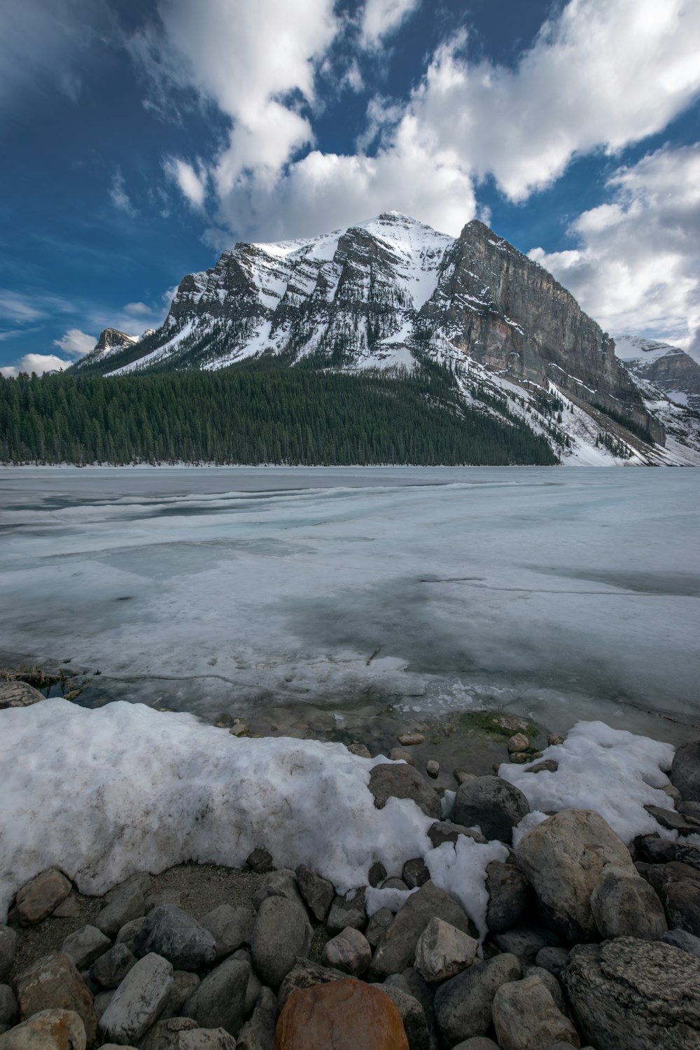 Une montagne est au loin avec de la glace au sol