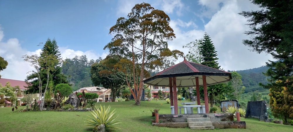 a gazebo sitting in the middle of a lush green park