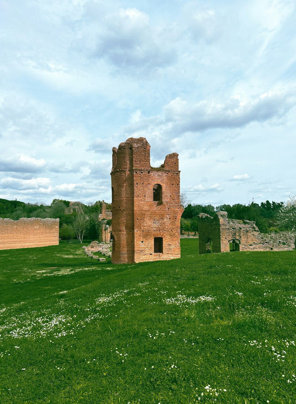 a large brick building sitting on top of a lush green field