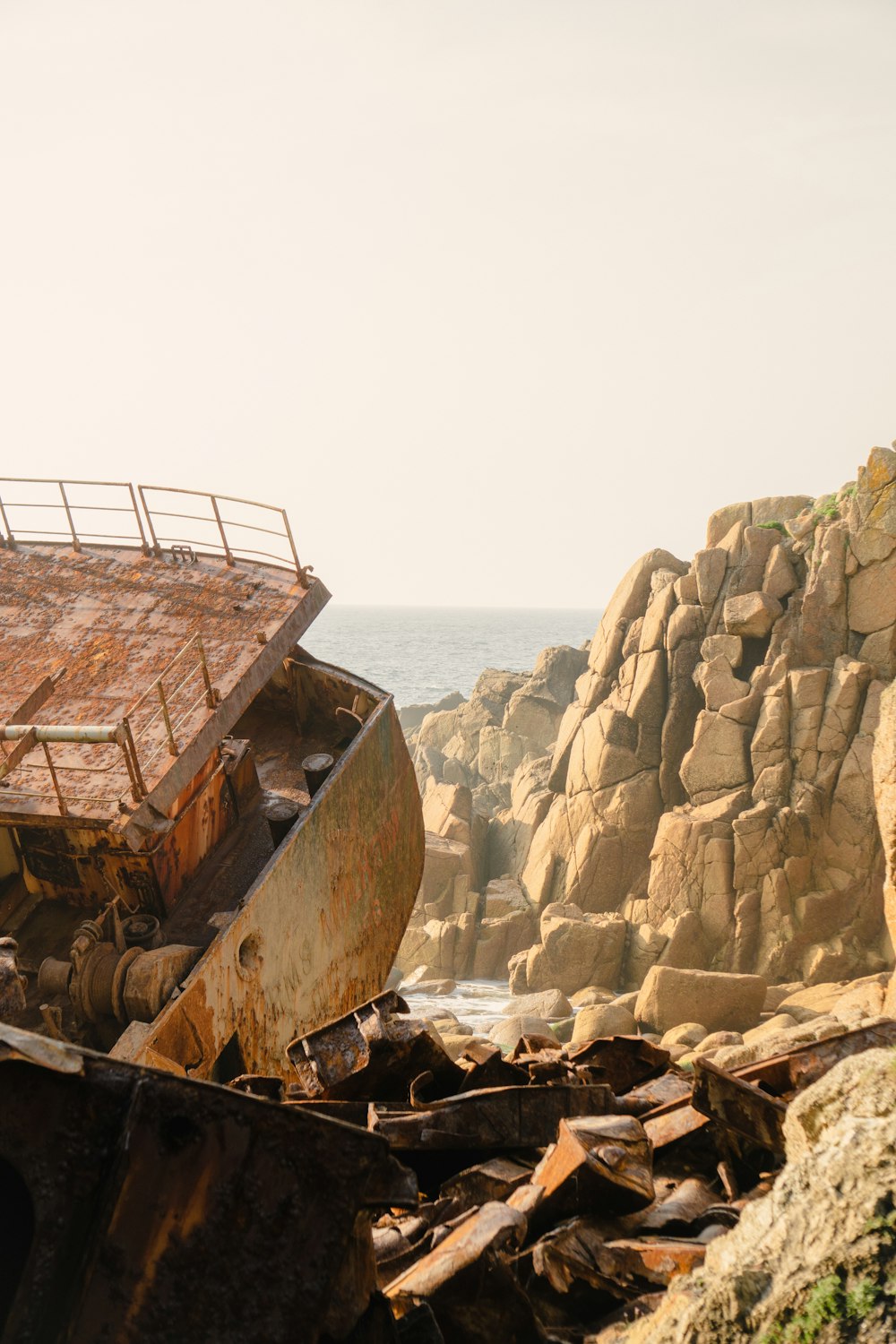 Un bote oxidado sentado en la cima de una playa rocosa