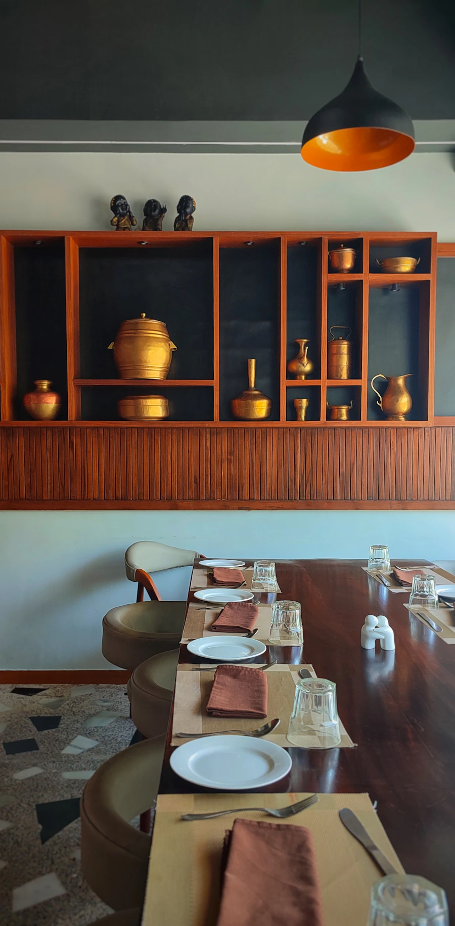 A long dining table laid with place settings and plates
