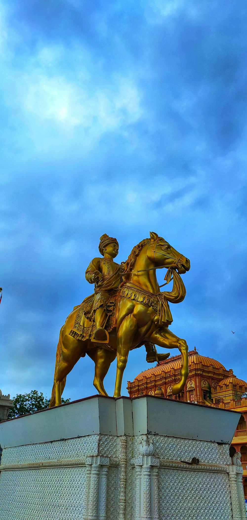 a golden statue of a man riding a horse