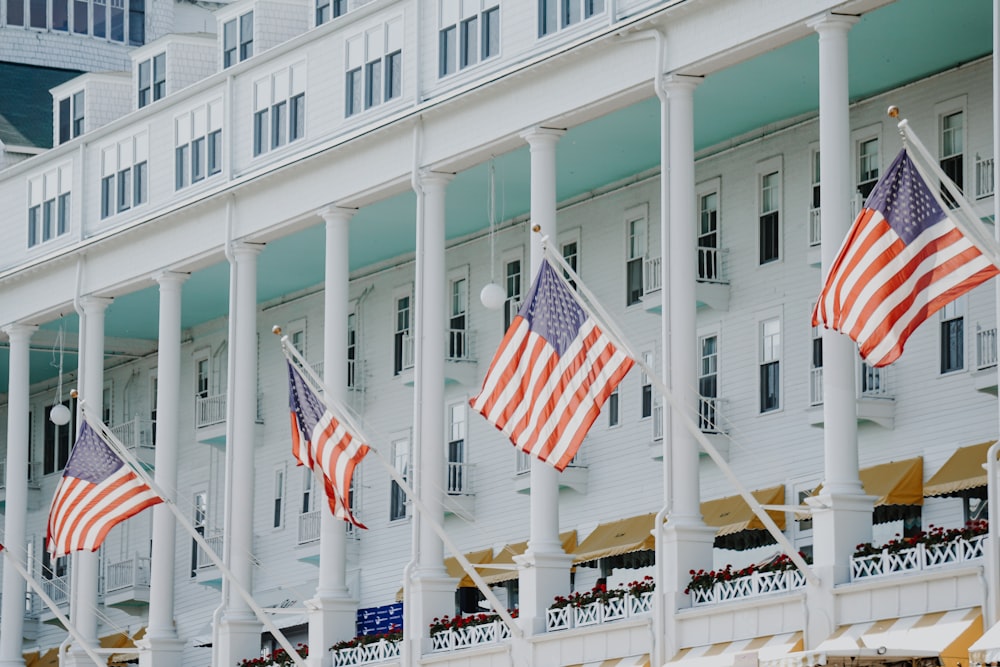 Uma fileira de bandeiras americanas hasteadas em frente a um hotel