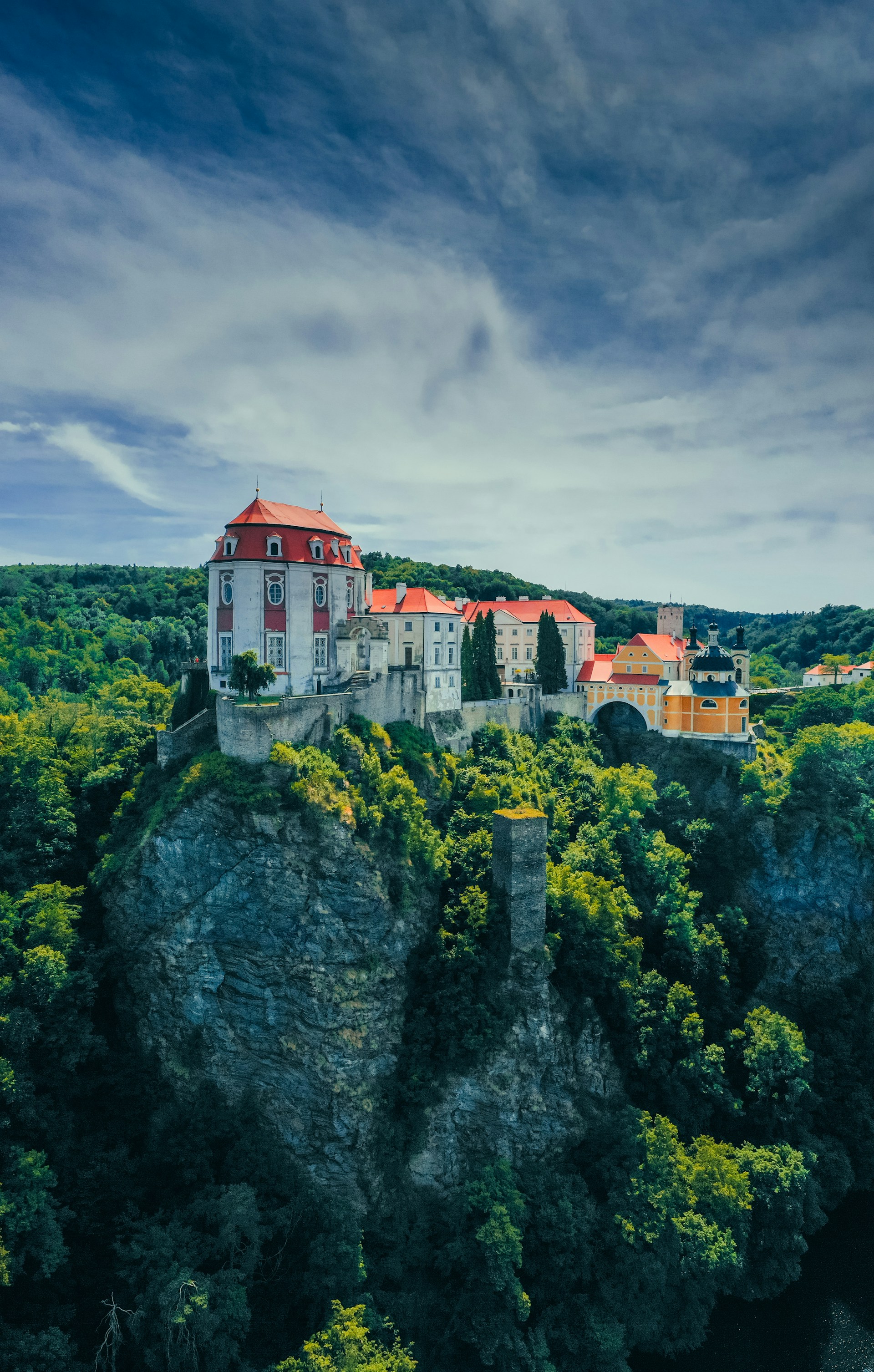a castle on top of a cliff surrounded by trees