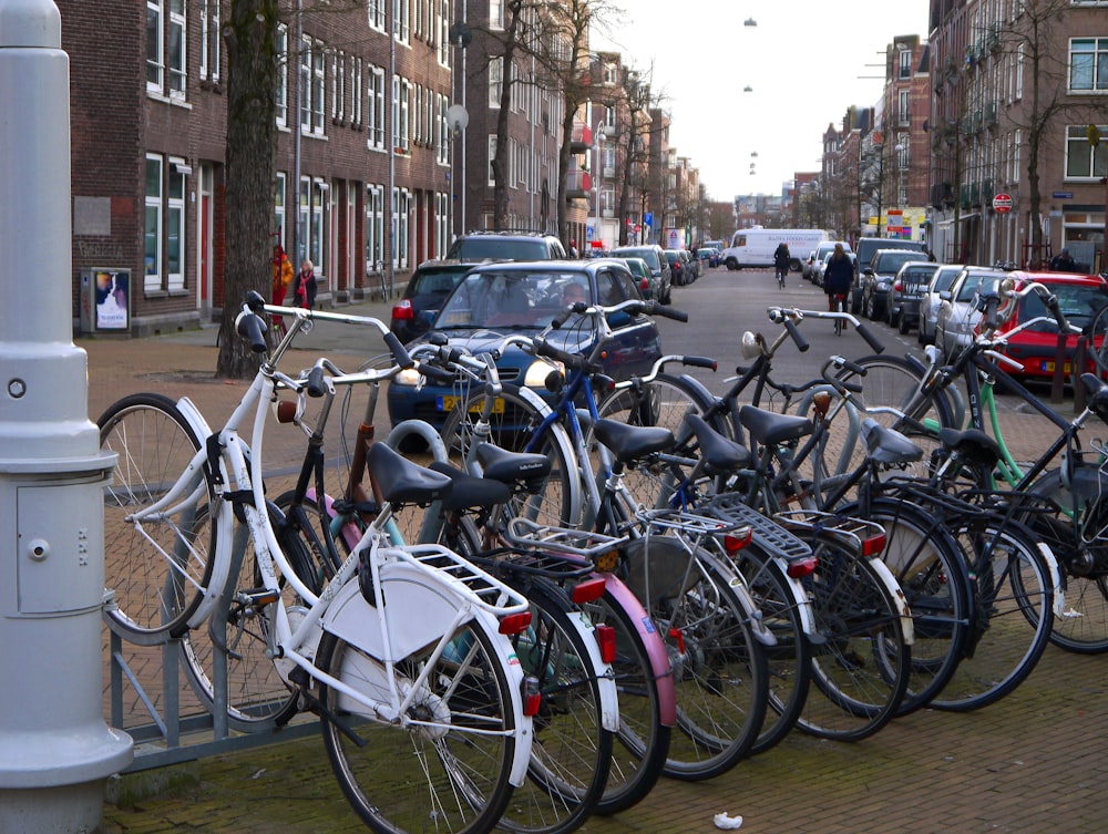 Una fila di biciclette parcheggiate una accanto all'altra su un marciapiede