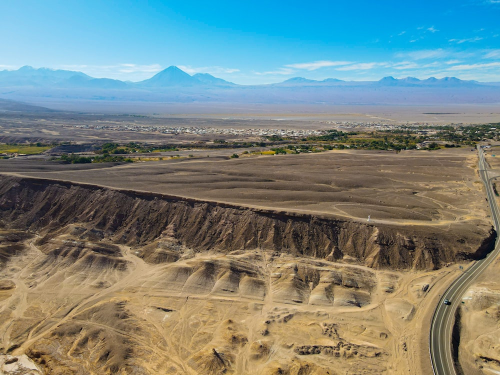 an aerial view of a desert with mountains in the background