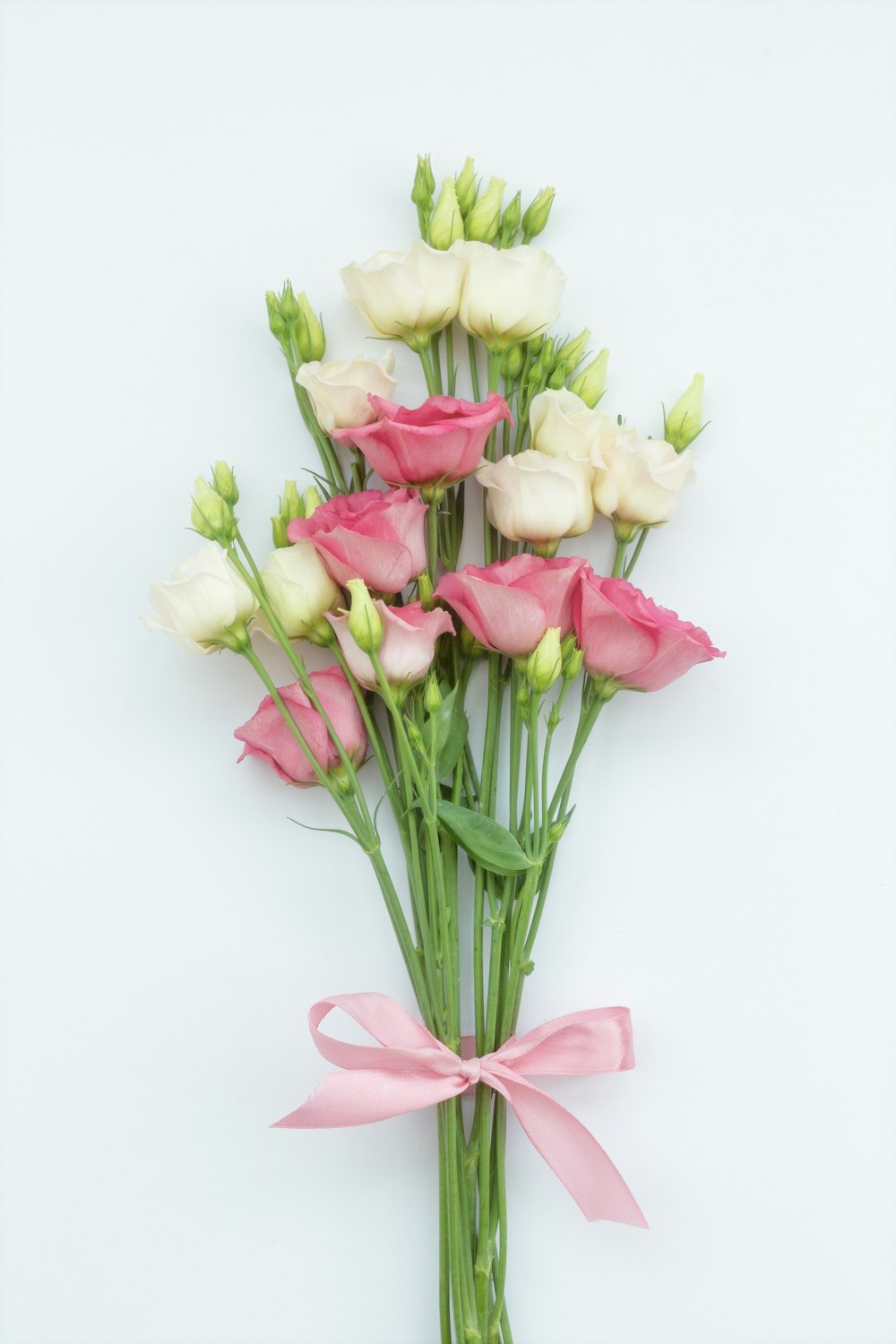un mazzo di fiori rosa e bianchi con un nastro rosa