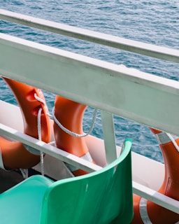 a row of orange and green chairs sitting on top of a boat