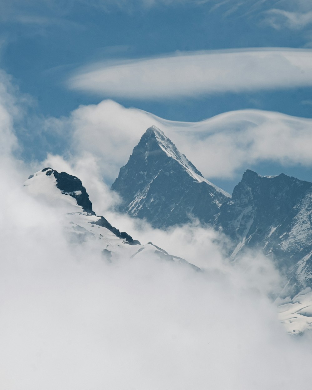 a view of a mountain with clouds in the foreground