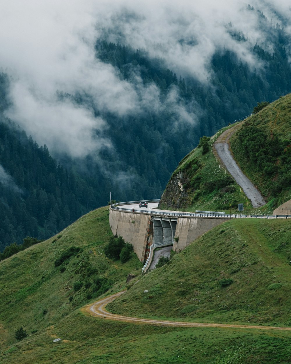 a road going up a hill with a bridge above it