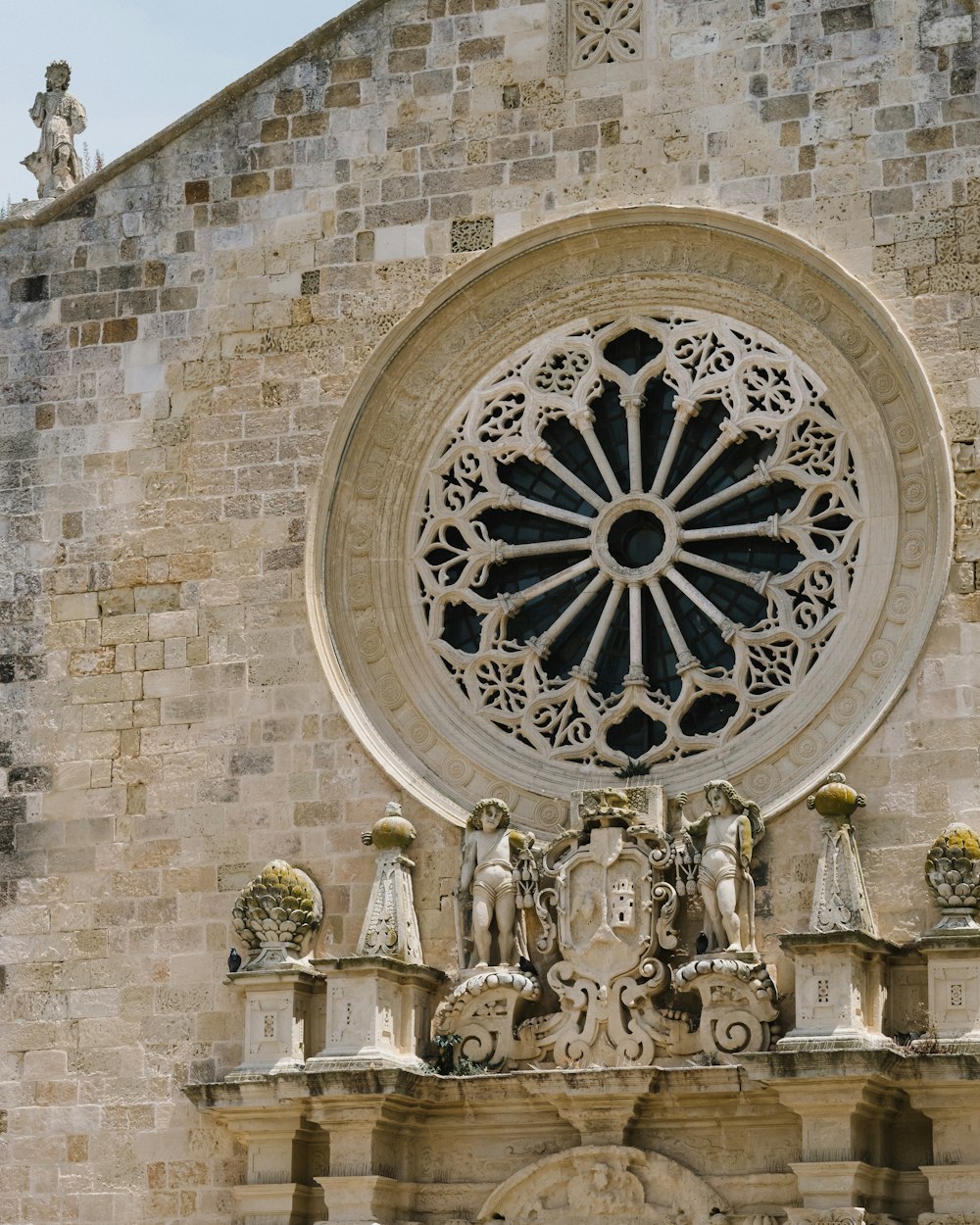 a stone building with a circular window above it