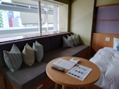 A cozy room featuring a mix of warm-toned flooring and tailored blinds creating a welcoming atmosphere.