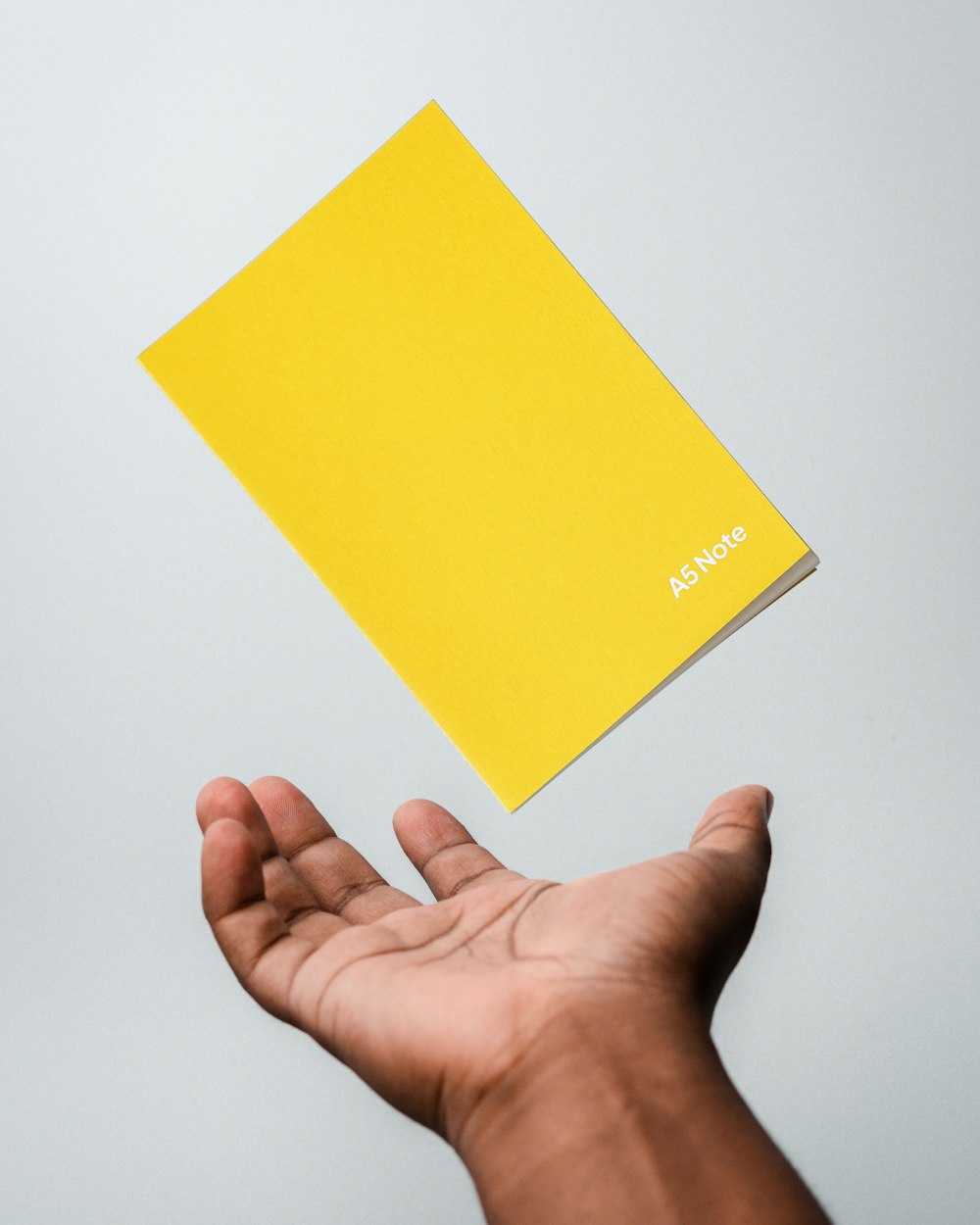 a person holding a yellow book in their hand