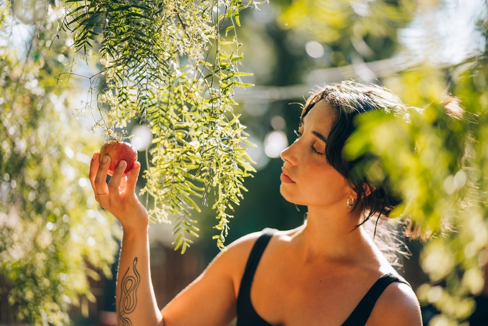 a woman is holding an apple in her hand