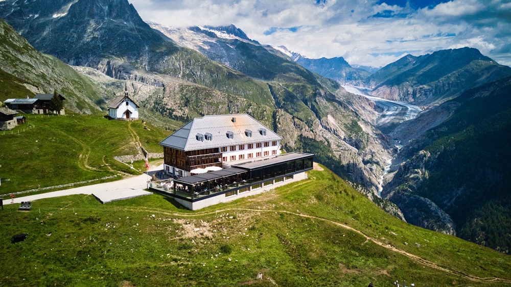 a house on top of a hill with mountains in the background