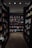 A well-organized aisle in a bookstore with shelves lined with a variety of books. The shelves are filled with colorful book covers, and there's a section labeled 'Mystery/Thriller'. Overhead lighting casts a warm glow on the book displays.