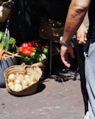 Close-up of hands holding fresh vegetables at a local farmers market.