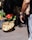 Photo of a happy man holding a basket of fresh vegetables in a market setting.