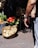 Photo of a happy man holding a basket of fresh vegetables in a market setting.
