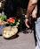 Smiling middle-aged woman holding a basket of fresh vegetables in a local marketplace.