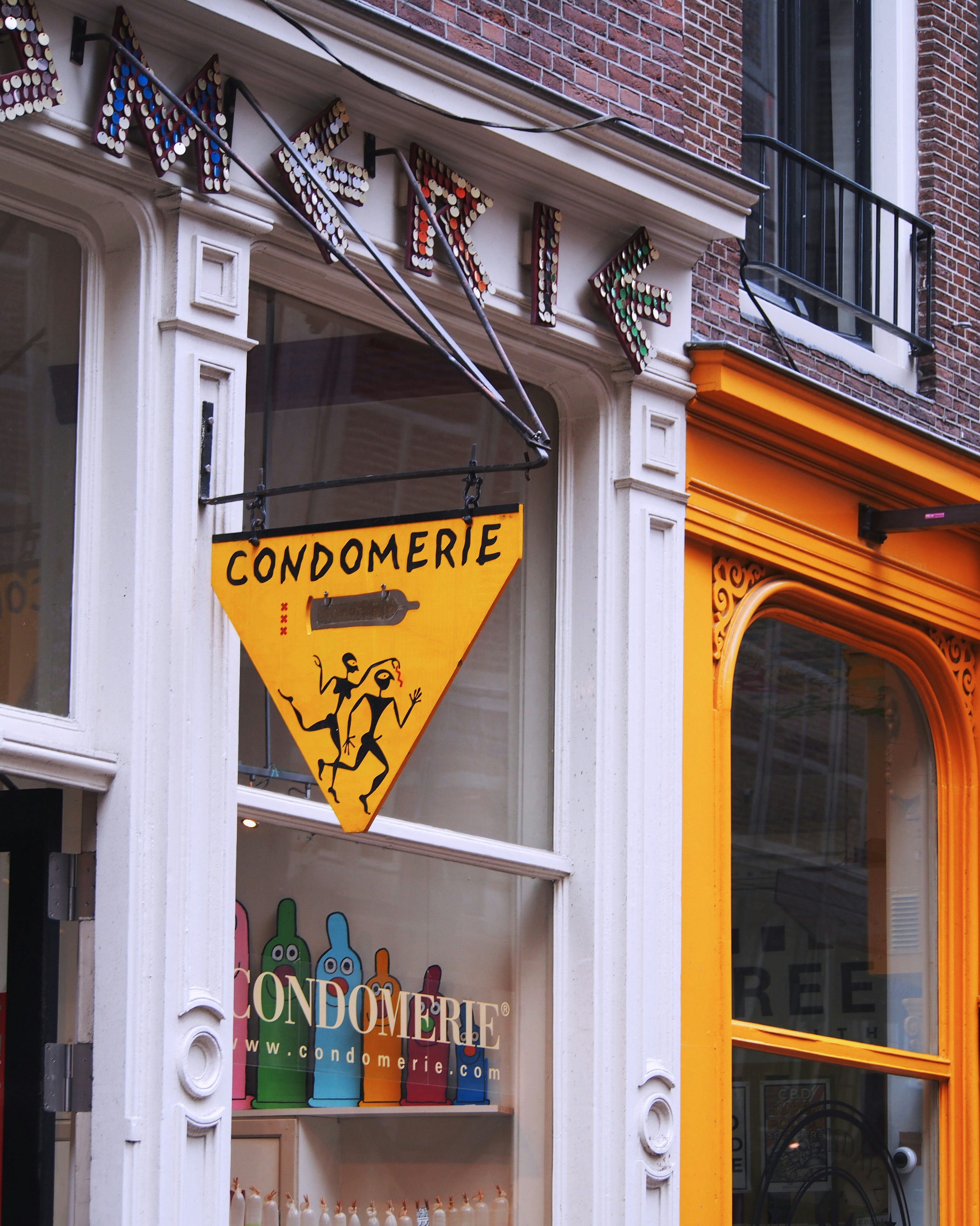 a yellow sign hanging from the side of a building
