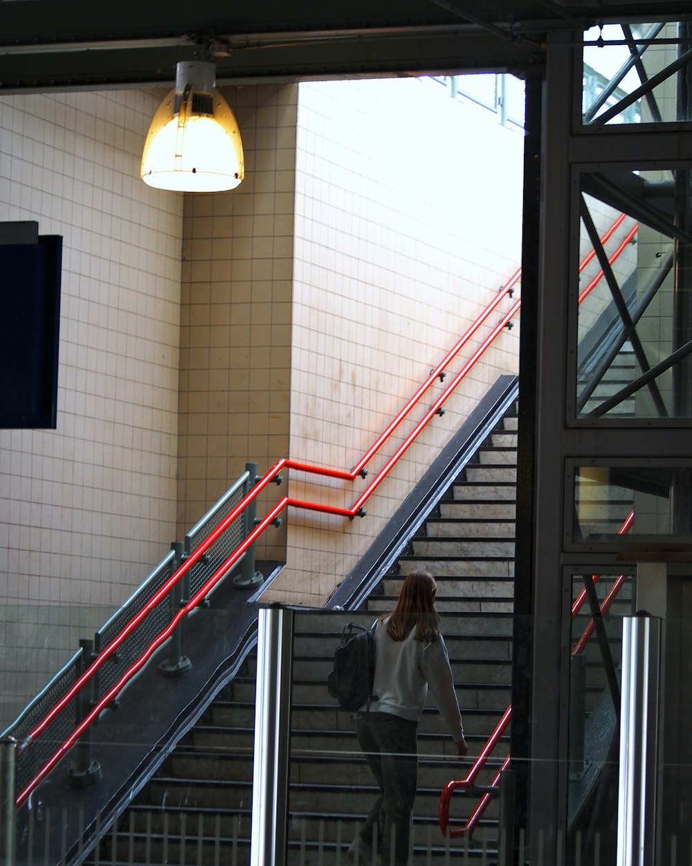 a woman with a backpack is walking up some stairs
