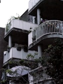 Close-up of modern balconies with glass railings overlooking lush landscaping.