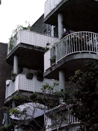 Close-up of modern balconies with glass railings overlooking lush landscaping.