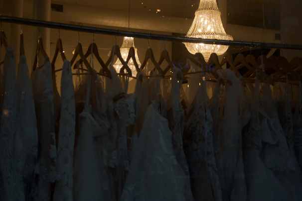 Elegant wedding dress hanging in a softly lit boutique setting