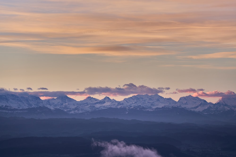 a view of a mountain range with clouds in the foreground