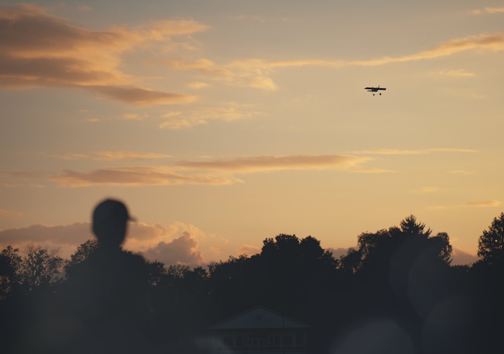 Un avion vole dans le ciel au coucher du soleil