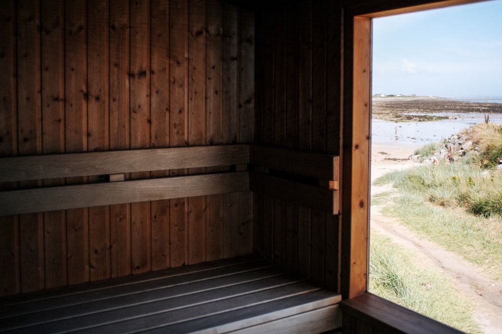 a wooden sauna with a view of a beach