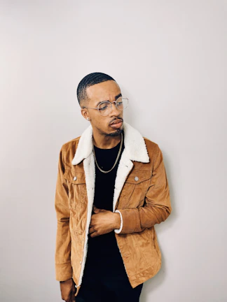 A model wearing the oxblood burgundy jacket standing against an airy, minimalist backdrop.