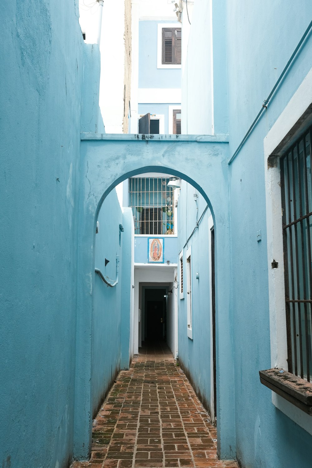 a narrow alley way with a blue building in the background