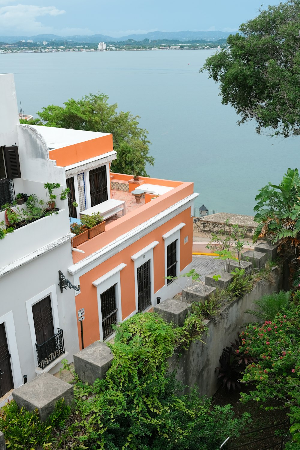 an orange and white house next to a body of water