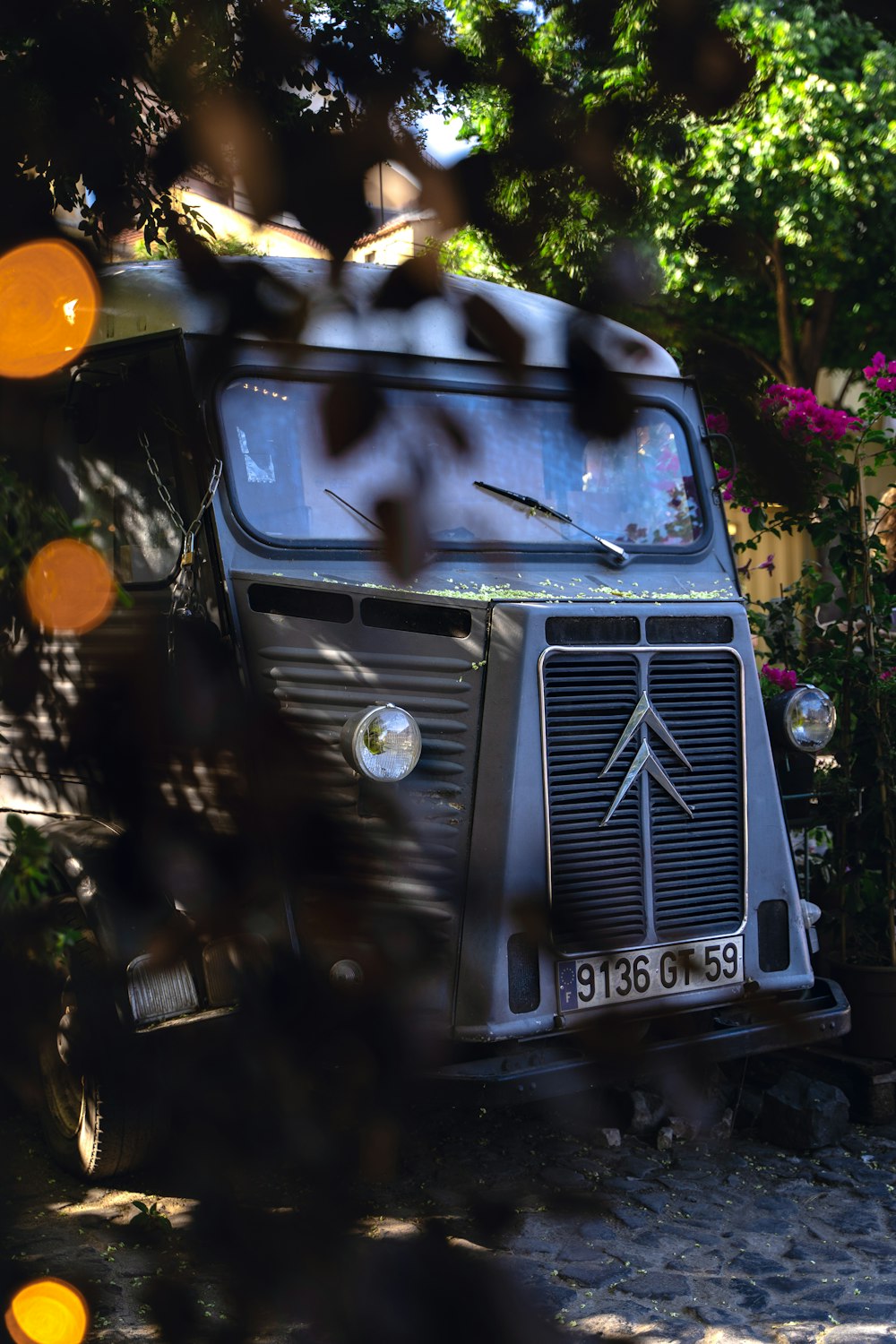 an old truck is parked in front of some trees