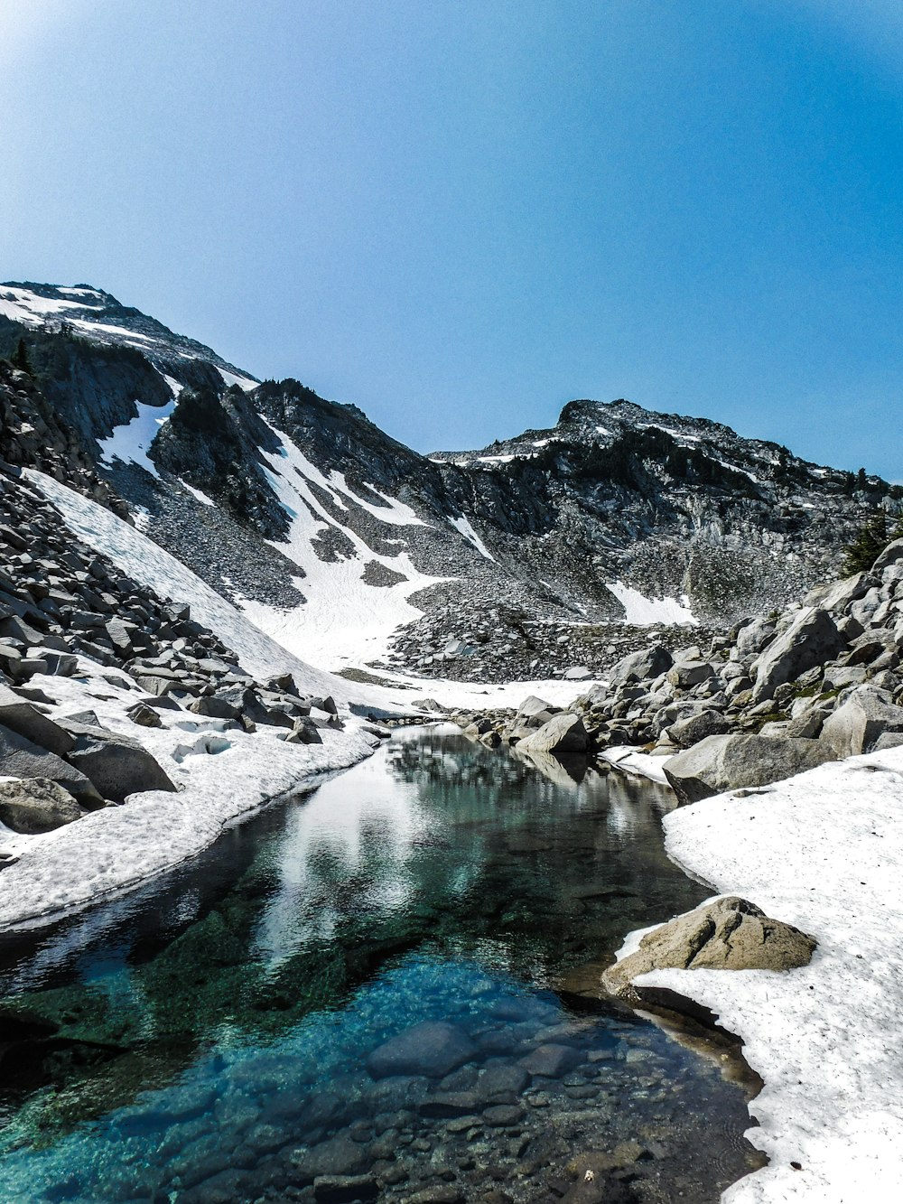 a snow covered mountain with a lake in the middle of it