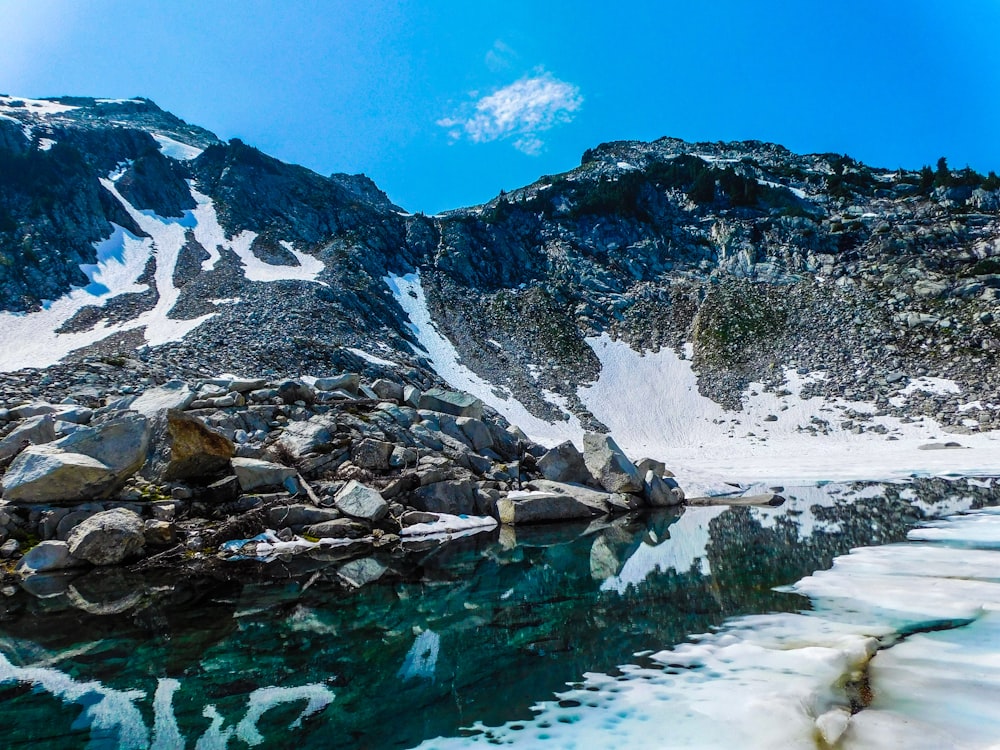 a snow covered mountain with a body of water in front of it